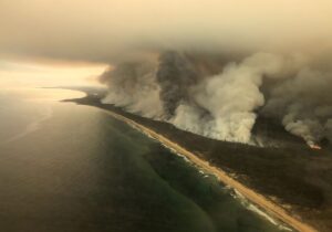 bushfires smoke plume aerial shot of coastal bush on fire