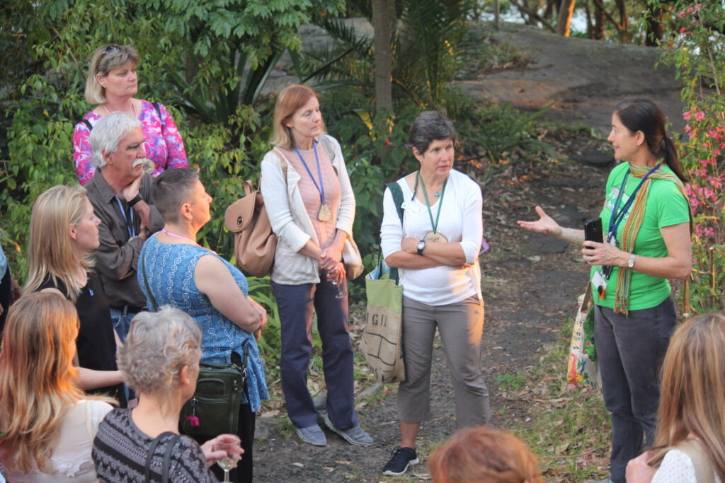 small group of adults standing talking outdoors