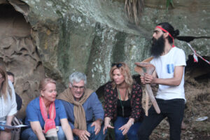people in rock cave learning from Indigenous teacher