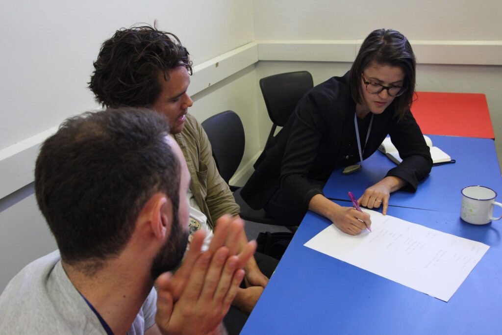 people sitting at desk working on document together