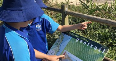 students read sign beach